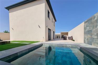 New built villa with 140 m² of living space and pool, in a residential area near the beach.