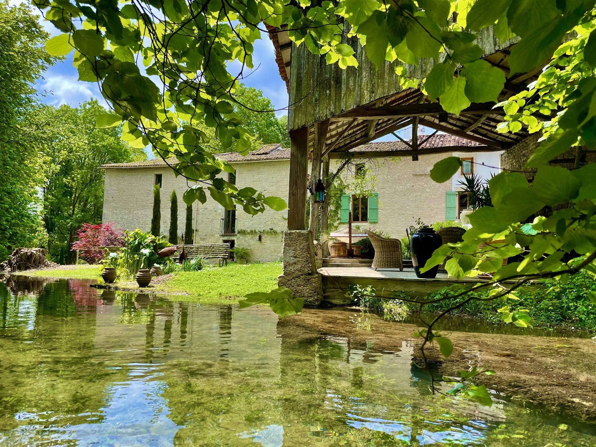 Vacker renoverad vattenkvarn med pool och exotiska trädgårdar