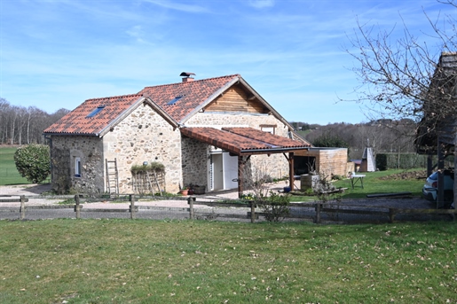 Group of stone houses with wooden extension in a natural setting in the Ségala region