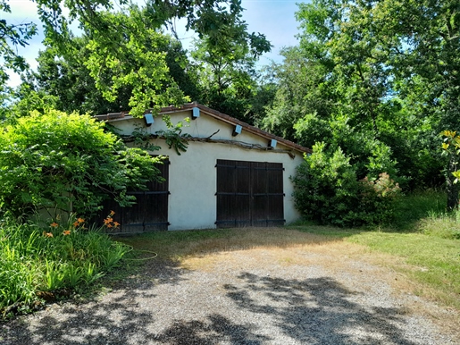 Casa con carácter en una ladera con piscina y jardín arbolado.