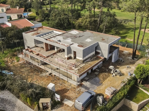 Maison contemporaine en cours de construction avec vue frontale sur le parcours de golf de Quinta do