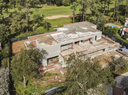 Maison contemporaine en cours de construction avec vue frontale sur le parcours de golf de Quinta do