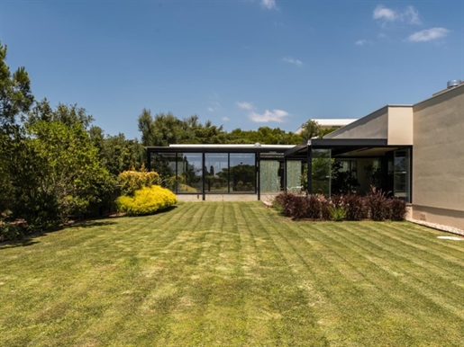 Situada no prestigiado Belas Clube de Campo, esta moradia isolada de arquitetura contemporânea ofere