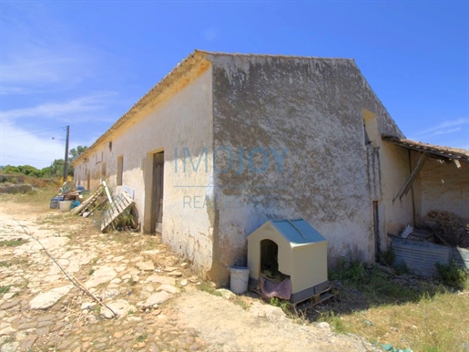 Land met ruïne en zeezicht in Ferragudo