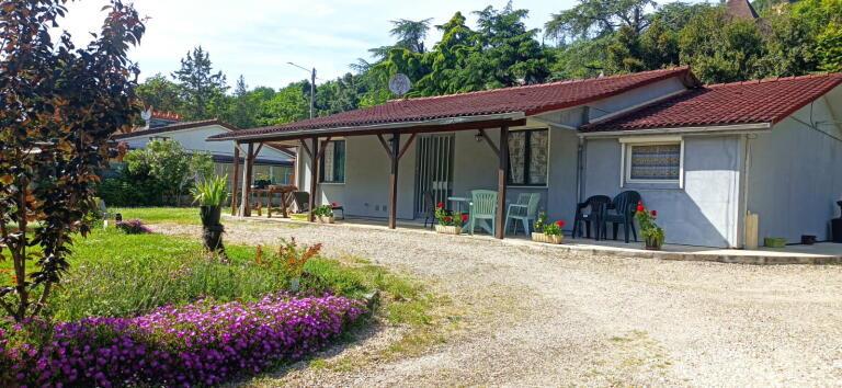 Casa de una sola planta con garaje y jardín.
