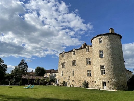 Mittelalterliche Burg in einem Park am Flussufer am Eingang eines historischen Dorfes und Turms