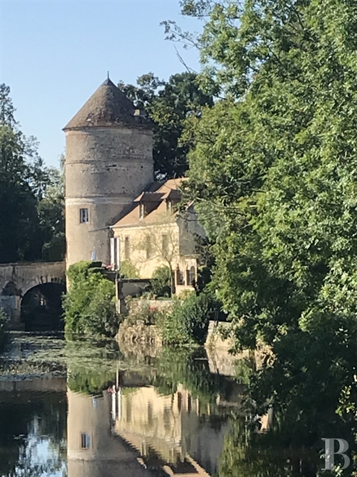 A 16th century dovecote, its house and a small jetty for boating on the river in a medieval Perche v