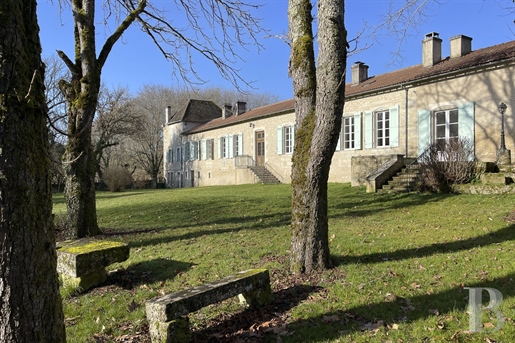 An 18th-century country house with many outbuildings in 12 hectares of grounds with a lake and strea