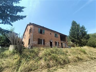 Rustiek bakstenen huis boven de glooiende heuvels van Monferrato
