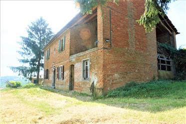 Rustic brick house above the rolling hills of Monferrato