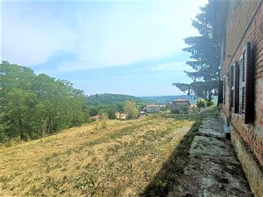Rustiek bakstenen huis boven de glooiende heuvels van Monferrato