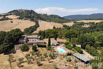 Stenen landhuis met bijgebouwen en zwembad op het Sienese platteland in Toscane