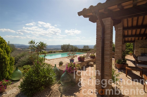 Maison en pierre avec tourelle, jardin et piscine en position panoramique avec vue sur Todi